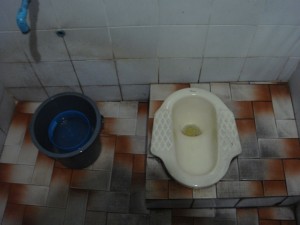 Thai style Squat Toliet with cleaning bucket and no TP