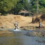 Dean and his KTM 950 SE powering out of a river in Laos
